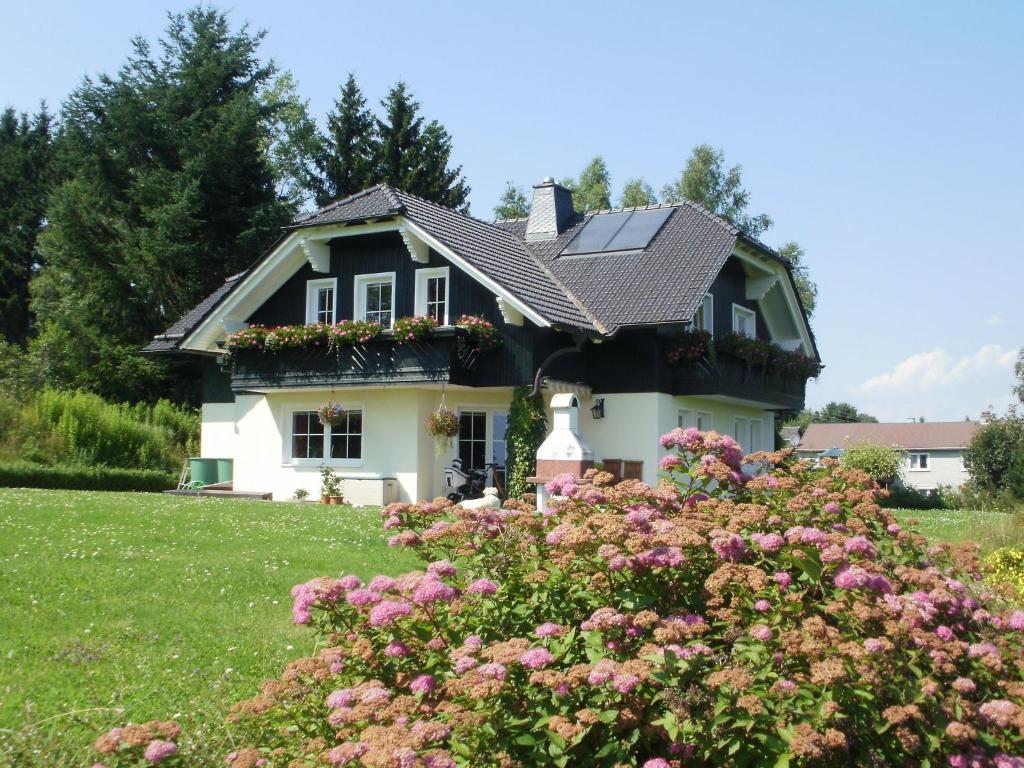 een huis met bloemen ervoor bij Apartment near the forest in Frauenwald