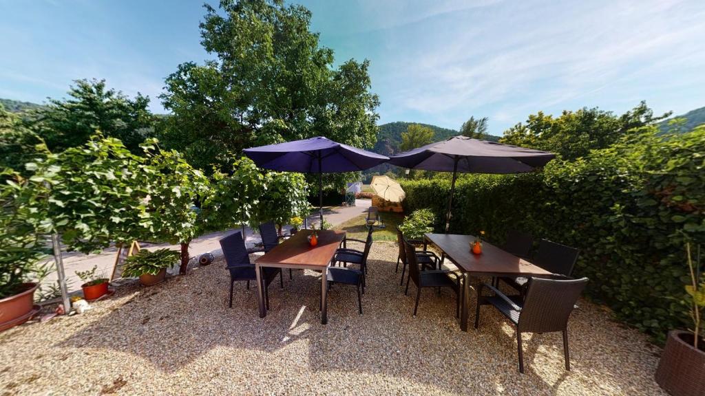 a patio with tables and chairs with umbrellas at Weingut Bäuerl in Dürnstein