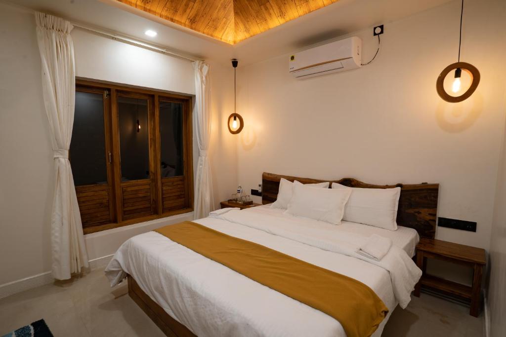 a bedroom with a large bed and a window at the woodland retreat in Dapoli