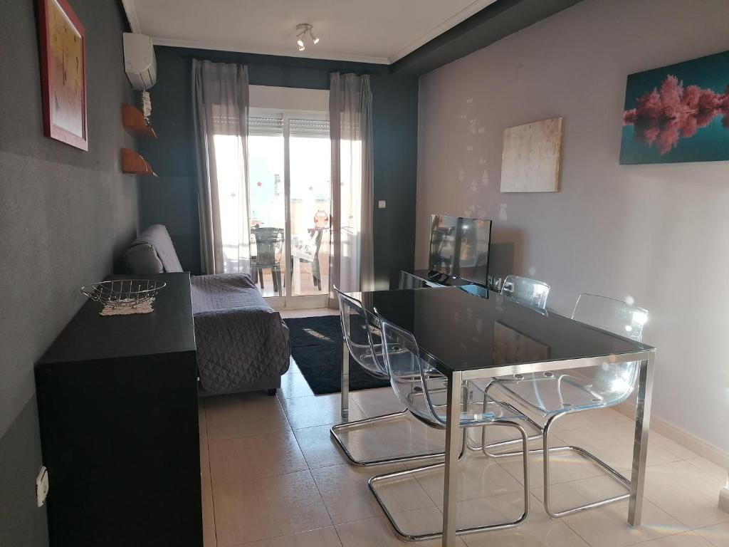 Zimmer mit einem Tisch und Stühlen sowie einem Schlafzimmer in der Unterkunft Sea and Relax Apartment By MM in Torrevieja