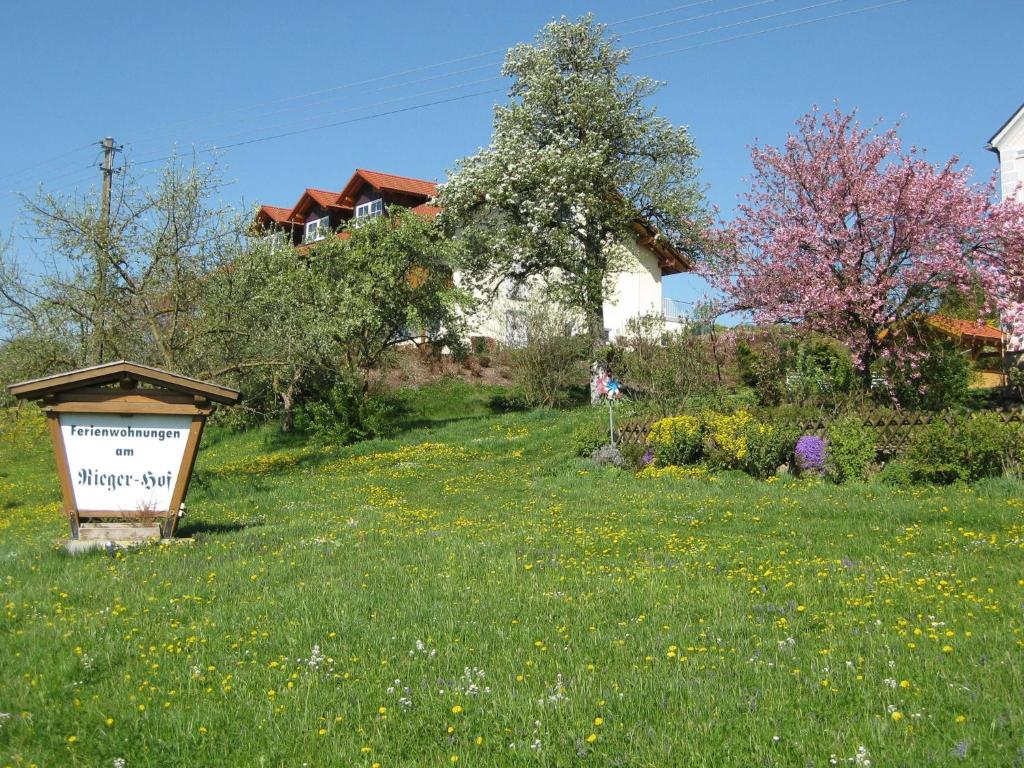 ein Schild auf einem Feld mit einem Haus im Hintergrund in der Unterkunft Apartment in Rotthalm nster with Private Terrace Garden BBQ in Rotthalmünster
