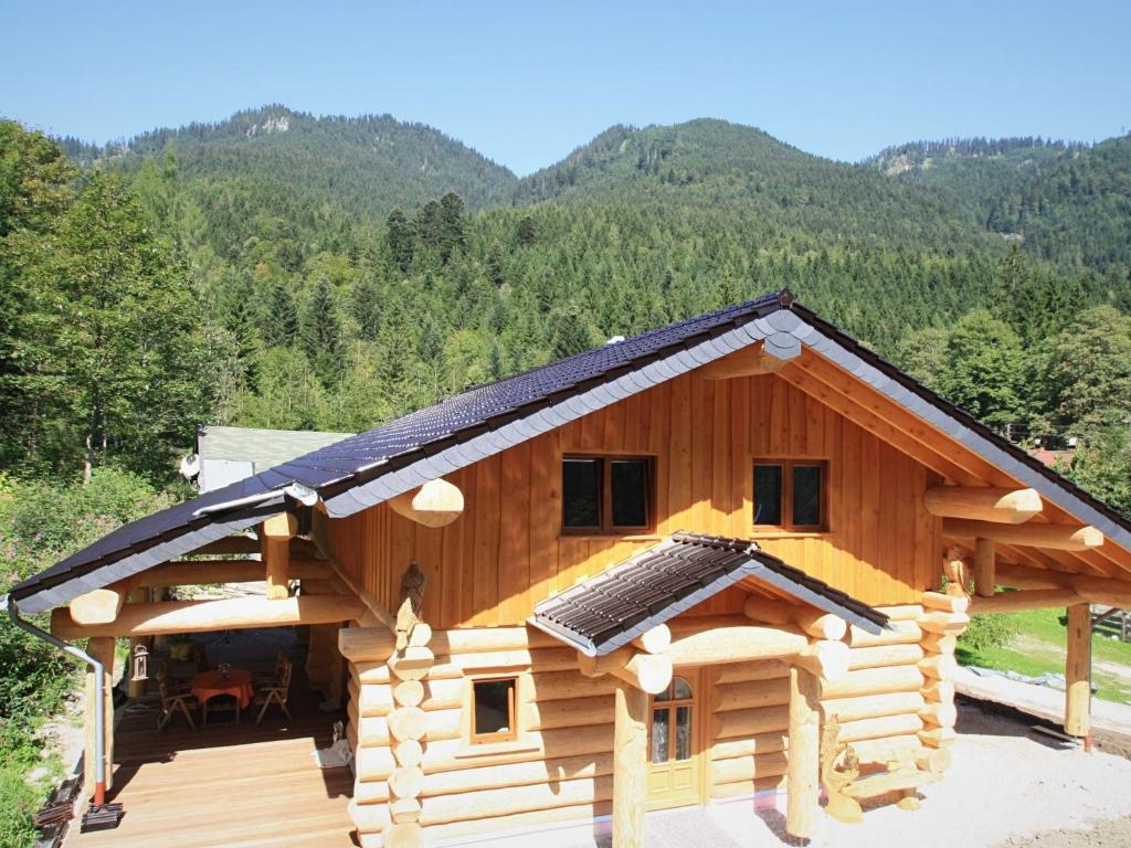 eine Blockhütte mit einem Gamerleich-Dach in der Unterkunft Unique Holiday Home in Ruhpolding Germany With Sauna in Ruhpolding