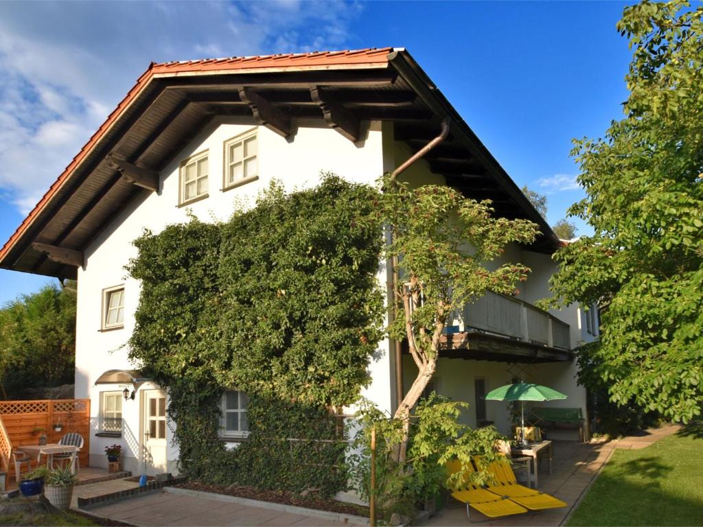 uma casa branca com uma grande árvore verde em Apartment in Regen with Terrace em Regen