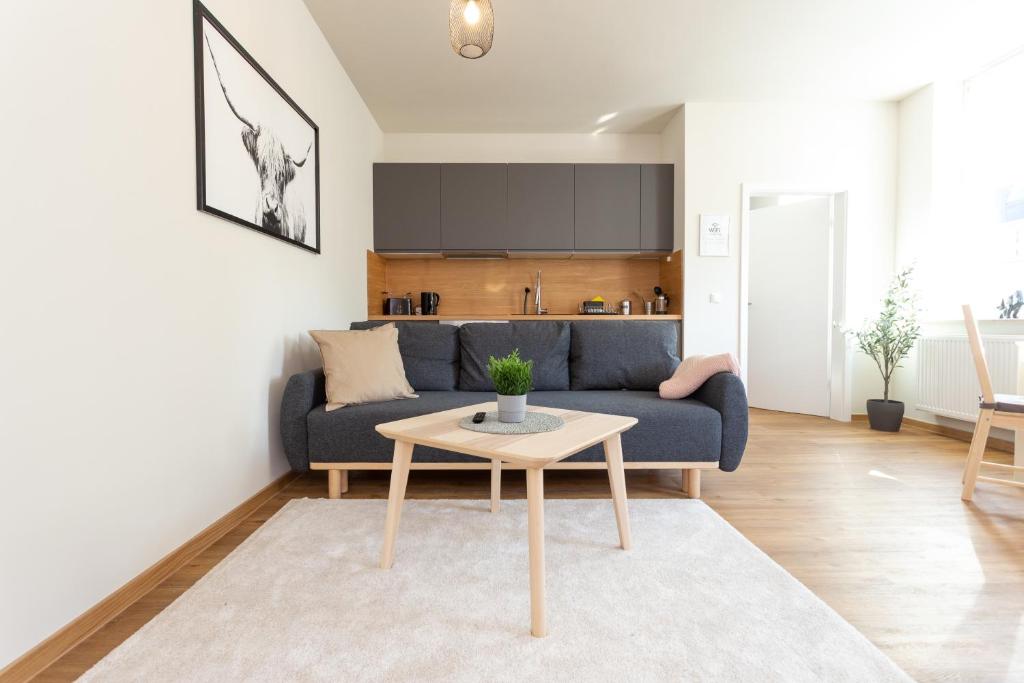 ein Wohnzimmer mit einem blauen Sofa und einem Tisch in der Unterkunft FULL HOUSE Studios - The Buffalo Apartment - WiFi in Zwickau