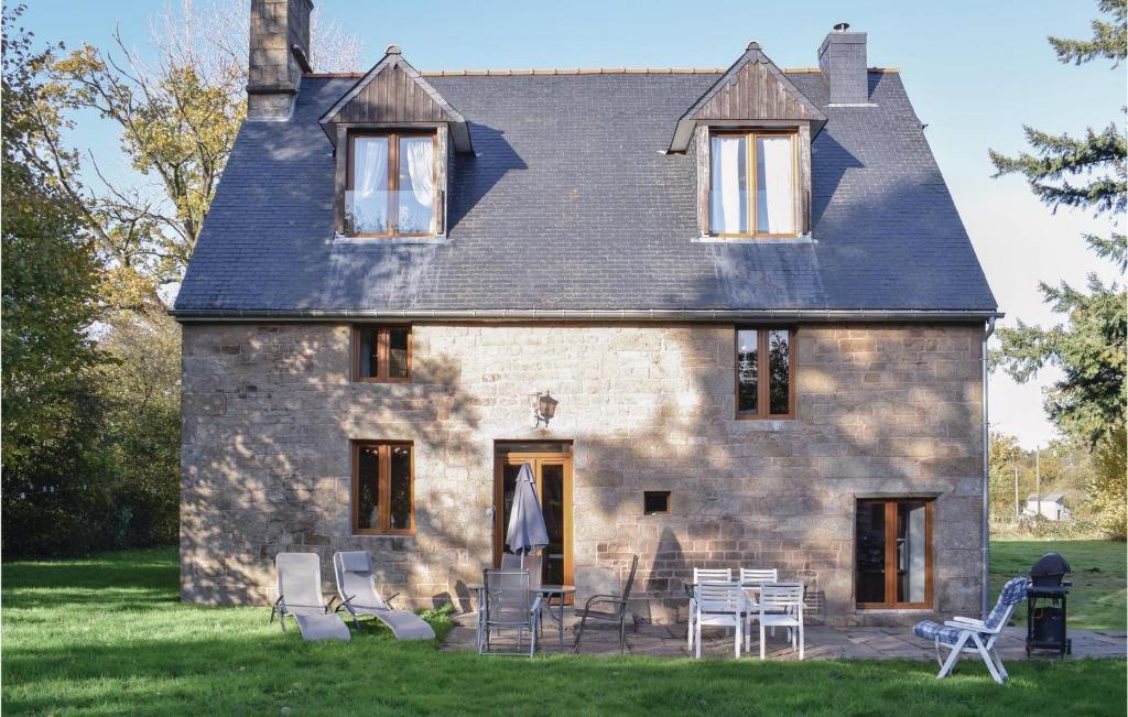 una vieja casa de piedra con sillas y mesas delante. en 3 Bedroom Gorgeous Home In Saint Manvieu Bocage en Saint-Manvieu-Bocage