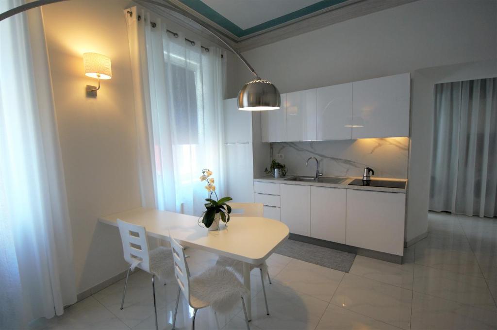 uma cozinha com uma mesa e cadeiras e um lavatório em Althamer Palace Apartments em Arco