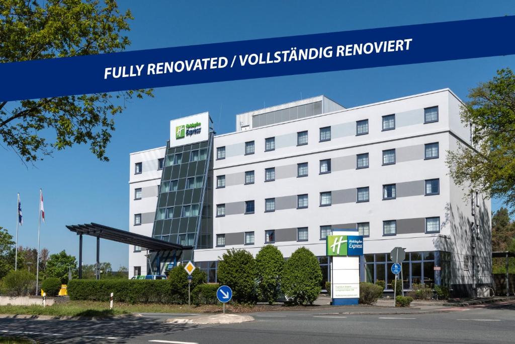 a white building with a sign that reads fully renovated yorkshire renewable network at Holiday Inn Express Frankfurt Airport, an IHG Hotel in Mörfelden-Walldorf