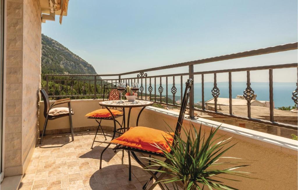 a balcony with a table and chairs and the ocean at Cozy Home In Makarska With Kitchen in Makarska
