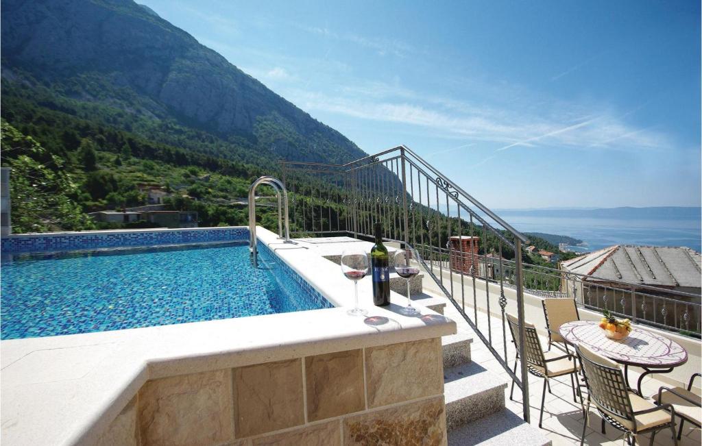 a swimming pool with a table and chairs on a balcony at Cozy Home In Makarska With Kitchen in Makarska
