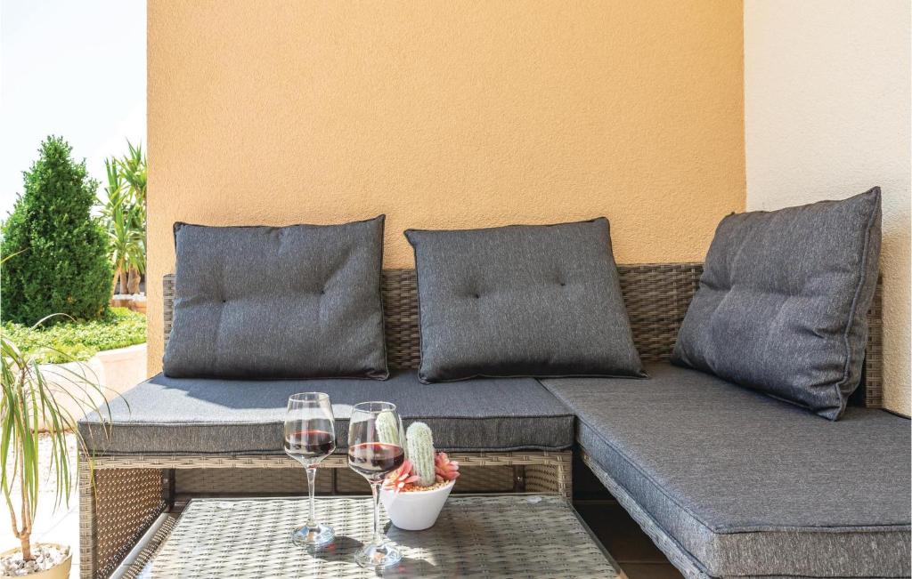 a couch with two glasses of wine on a patio at Cozy Home In Makarska With Kitchen in Makarska
