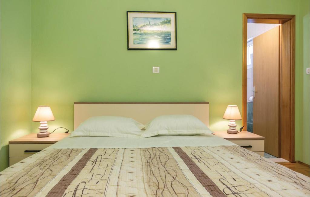 a bedroom with a large bed with two lamps at Cozy Home In Makarska With Kitchen in Makarska