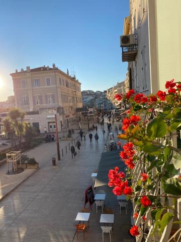 une rue de la ville avec des tables, des chaises et des fleurs rouges dans l'établissement M.M.R. Au cœur de la vie cannoise, à Cannes