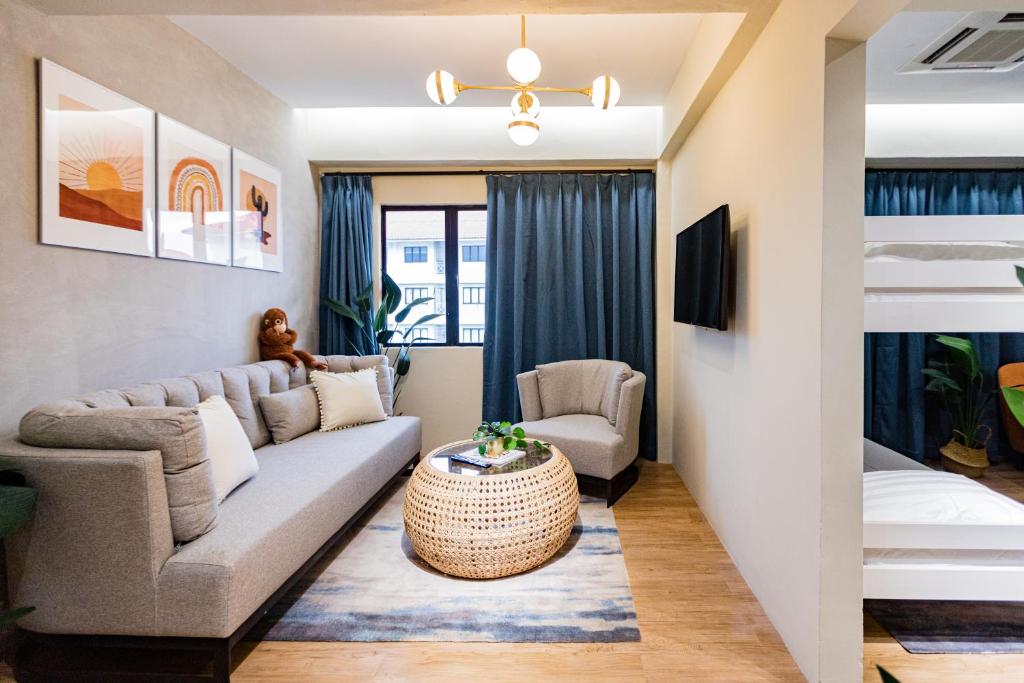 A sitting area with a sofa, armchairs, television and a glimpse of bunk-bed accommodation.