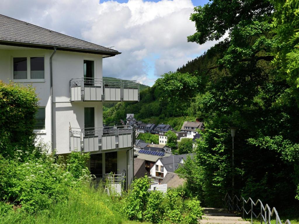 ein weißes Haus mit Balkon in einem Dorf in der Unterkunft Apartment on the 2nd floor with balcony and nice views in the centre of Willingen in Willingen