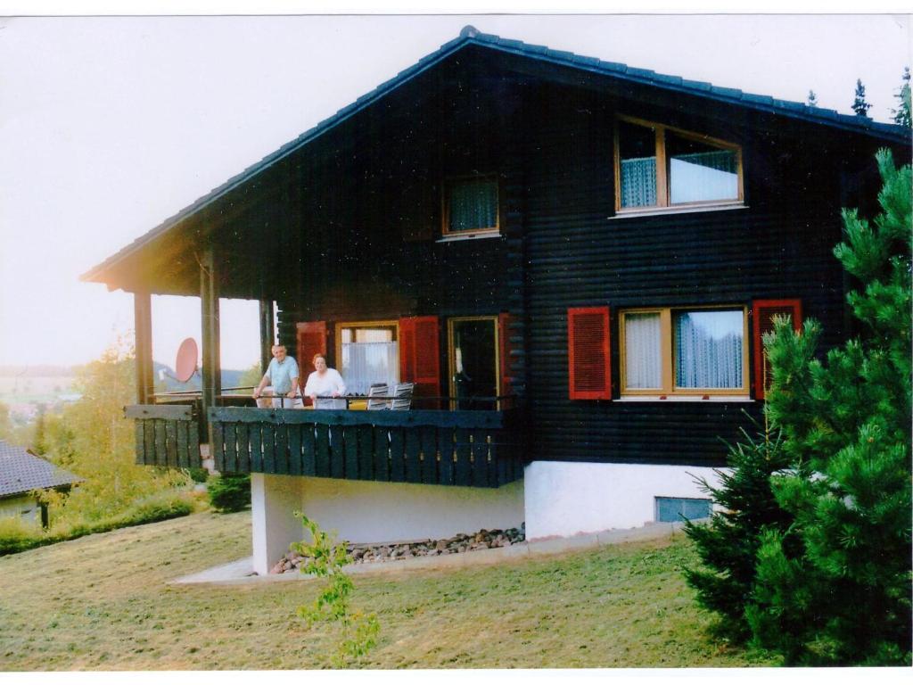 two people standing on the porch of a house at Relaxing holiday home in Deilingen with terrace in Deilingen