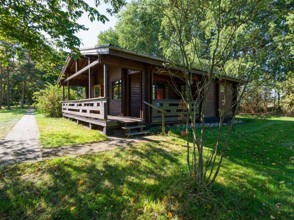 EschedeにあるCozy holiday home on a horse farm in the L neburg Heathの木の植わる公園内のログキャビン
