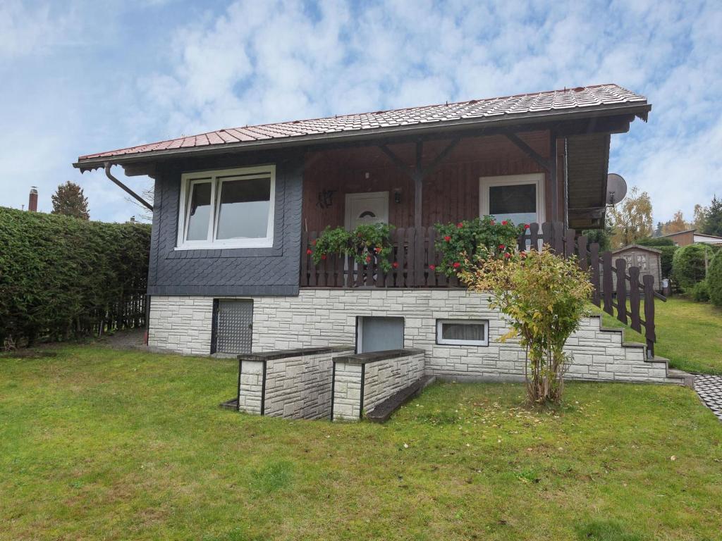 una pequeña casa con una valla en el patio en Holiday home with garden, en Altenfeld