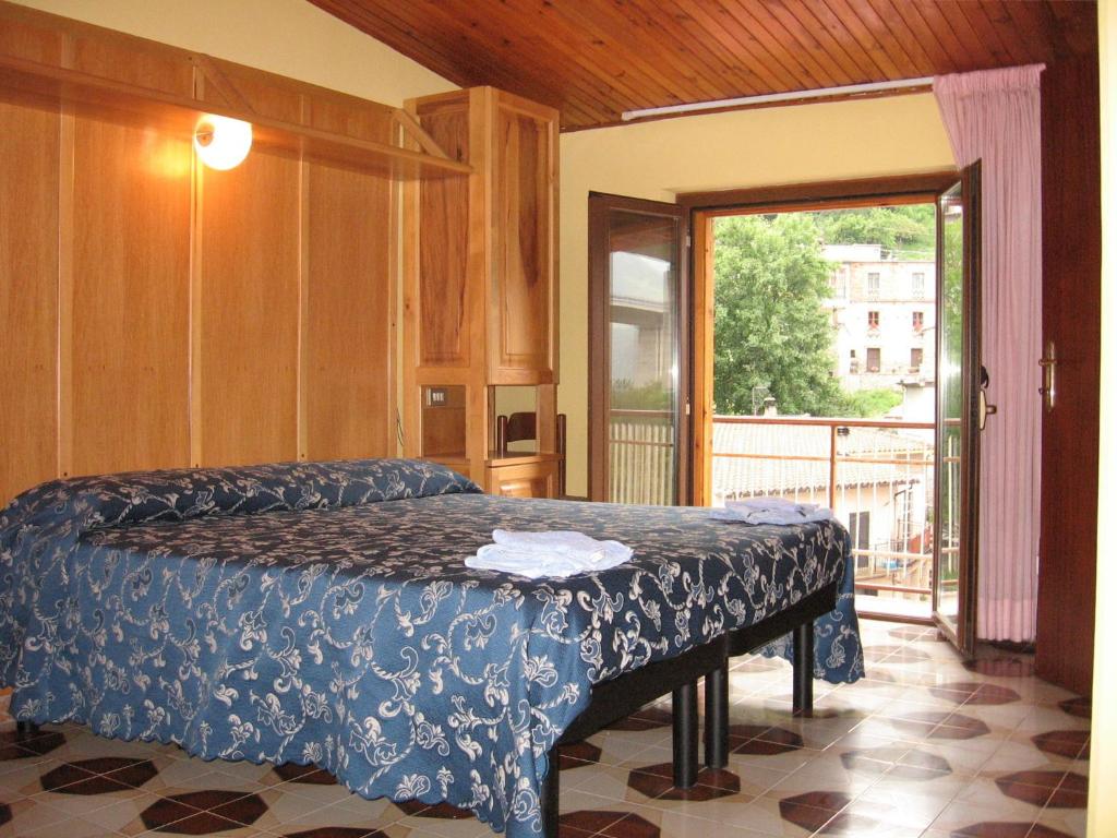 a bedroom with a bed and a sliding glass door at Hotel Casale in Isola del Gran Sasso dʼItalia