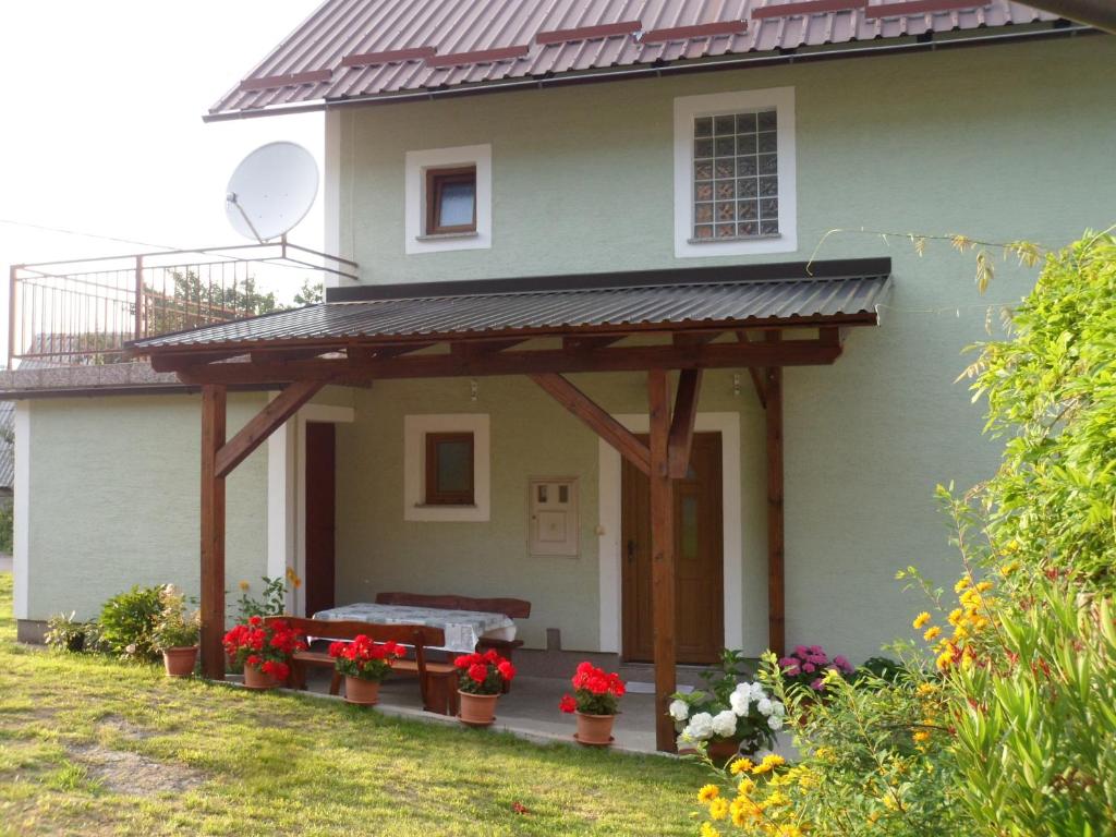 una casa con una pérgola en la parte delantera en Vacation home Kuća za Odmor, en Krasno Polje