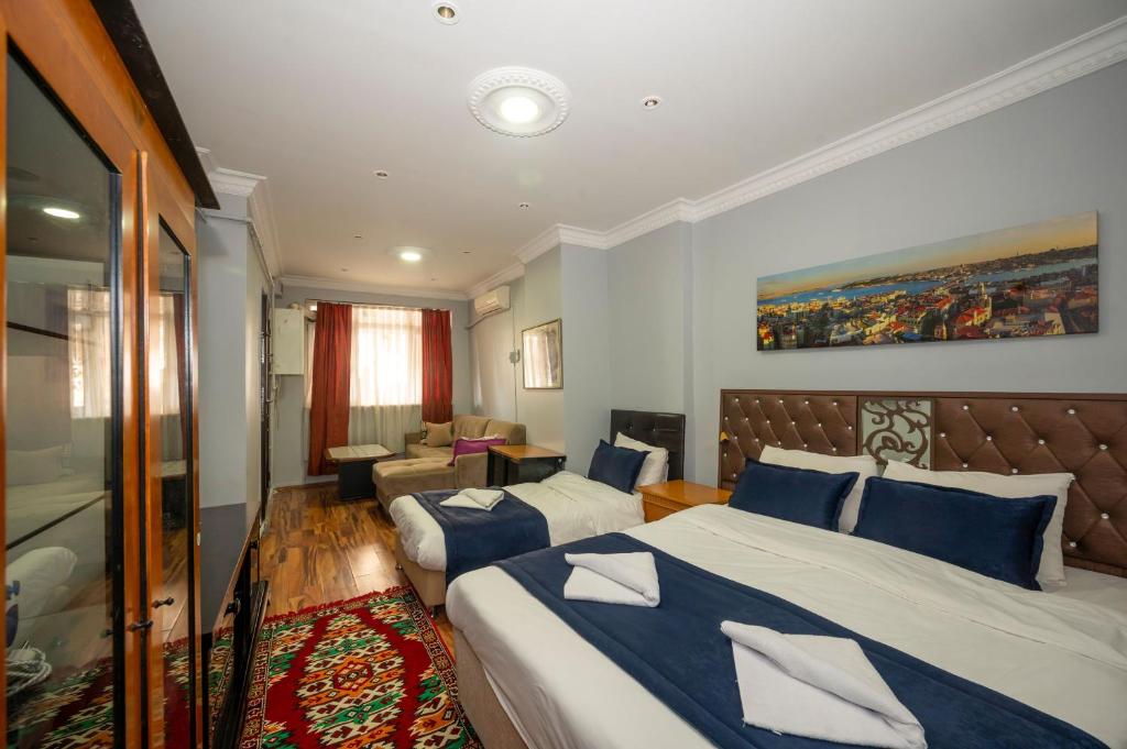 イスタンブールにあるタクシム スイート - llのベッド2台とソファが備わるホテルルームです。