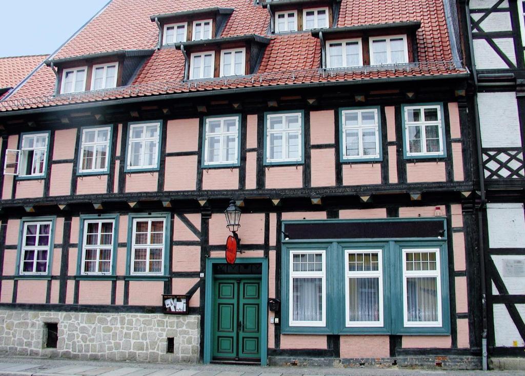 un edificio con una puerta verde y un techo rojo en Hotel garni "Alter Fritz", en Quedlinburg