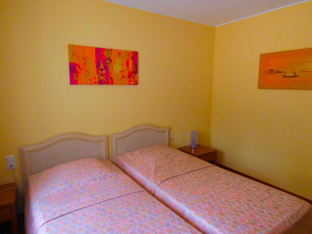 a bedroom with two beds and two paintings on the wall at Meyer Appartments in Beaufort