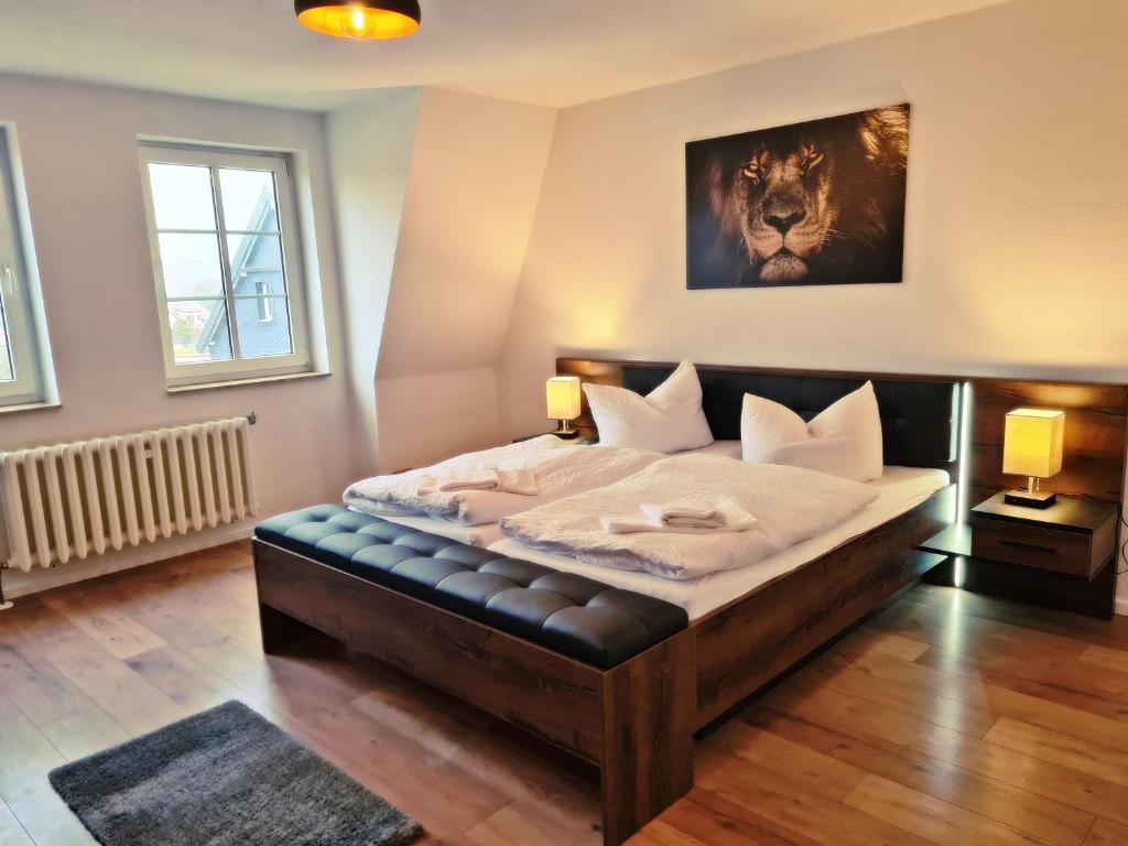 a bedroom with a large bed with a black leather seat at Hotel Deutsches Haus in Dingelstädt