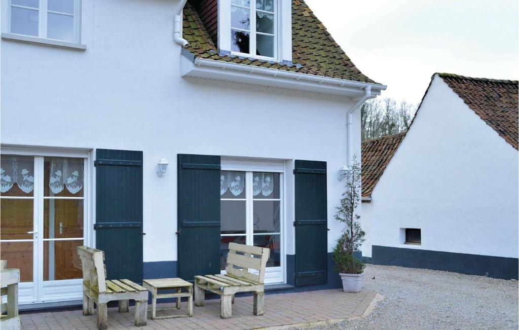 a white house with two benches in front of it at Cozy Apartment In Alette With Wifi in Alette