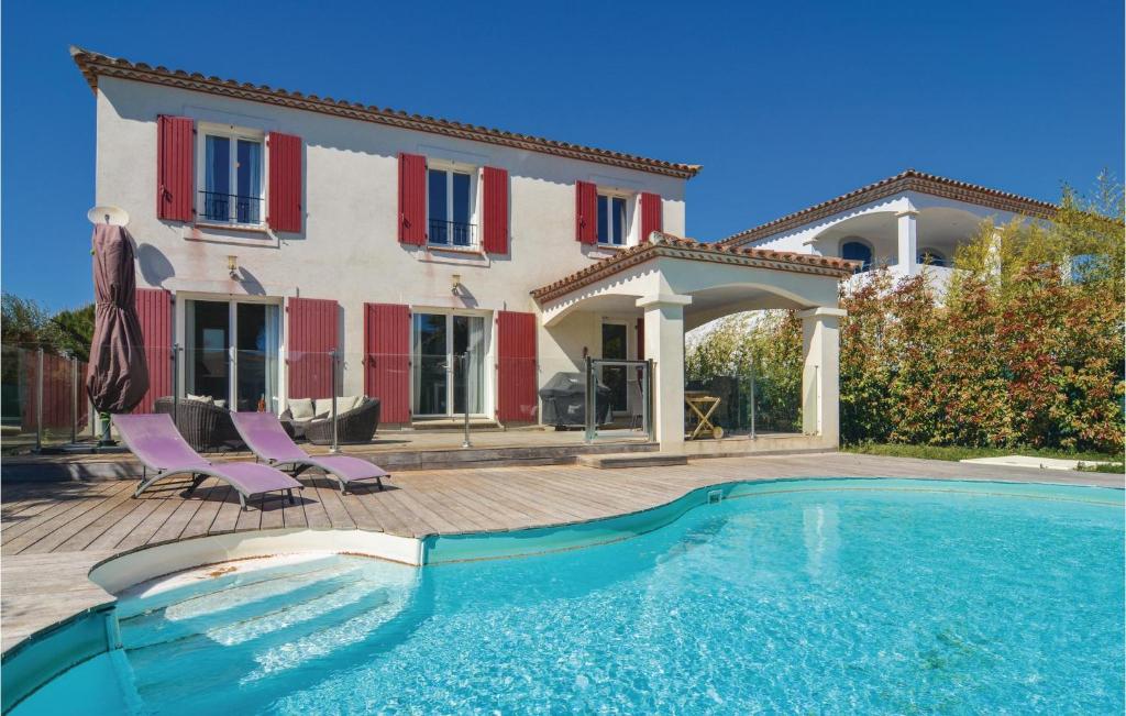 エーグ・モルトにあるAmazing Home In Aigues-mortes With 4 Bedrooms, Wifi And Outdoor Swimming Poolの家の前にスイミングプールがある家