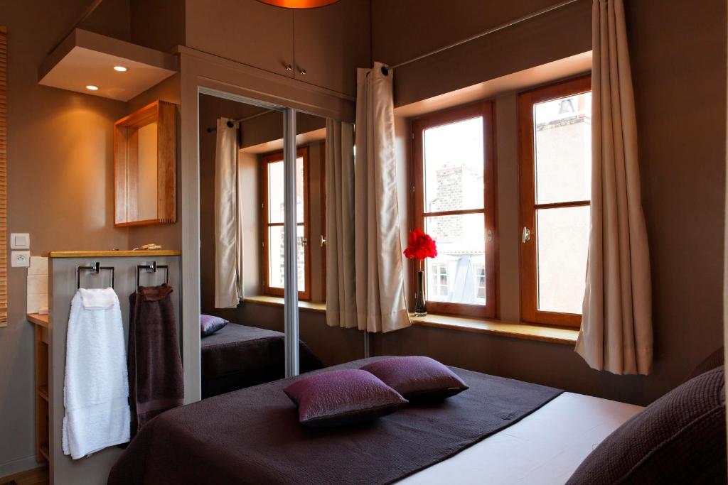 um quarto com uma cama e uma janela em Les Toits de Lyon em Lyon