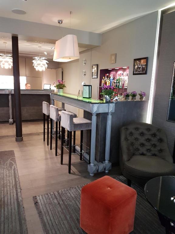 a bar with stools and a table in a room at Hôtel Harvey in Paris