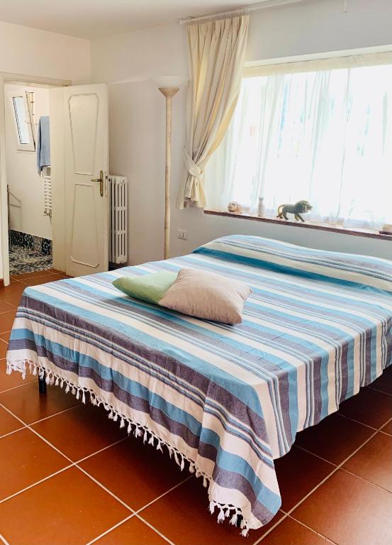 sypialnia z łóżkiem z paskowym kocem w obiekcie La stanza col giardino w mieście Bagno a Ripoli