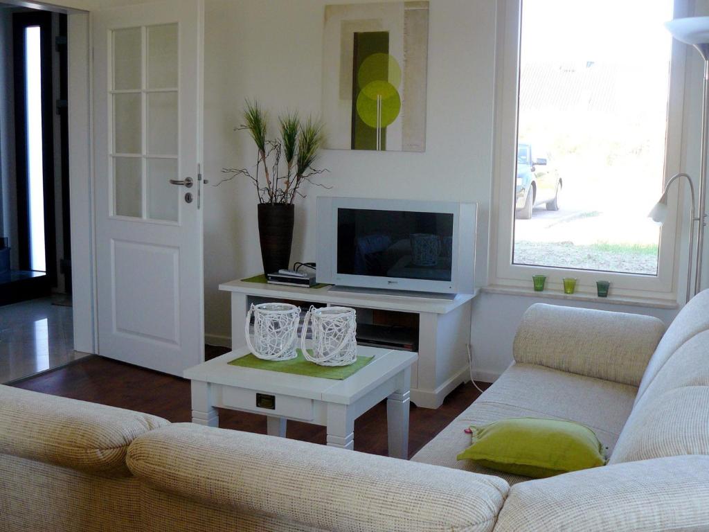 Una sala de estar con un sofá y una mesa con televisión. en Ferienhaus in der Lüneburger Heide, en Wietzendorf