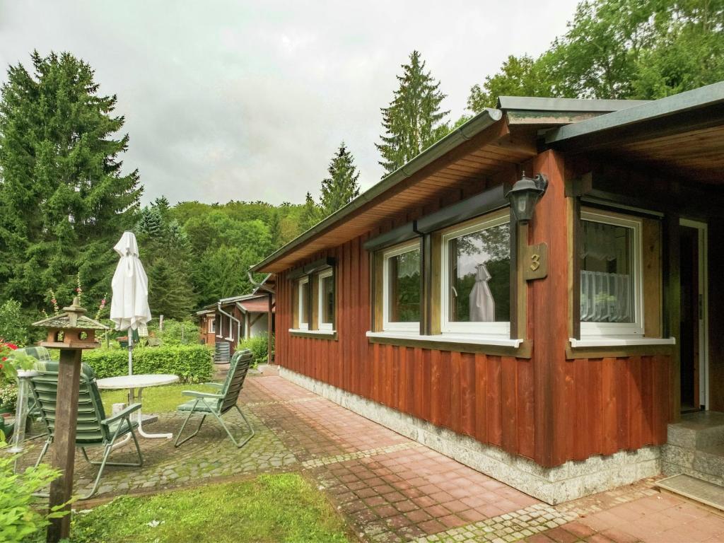 a tiny house with a patio and a table and chairs at Bungalow in Neustadt nahe Barbarossa Höhle in Neustadt