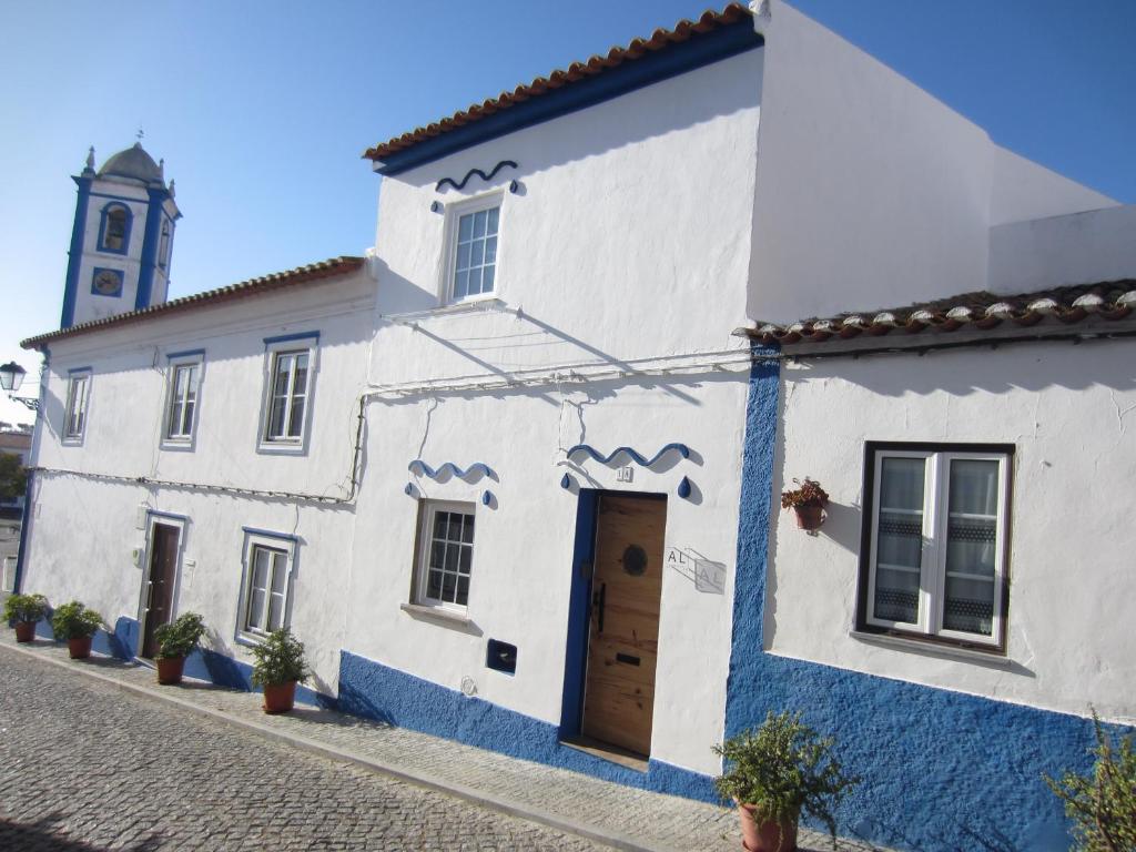 um edifício branco e azul com uma torre de relógio ao fundo em A Praia da Messejana em Messejana