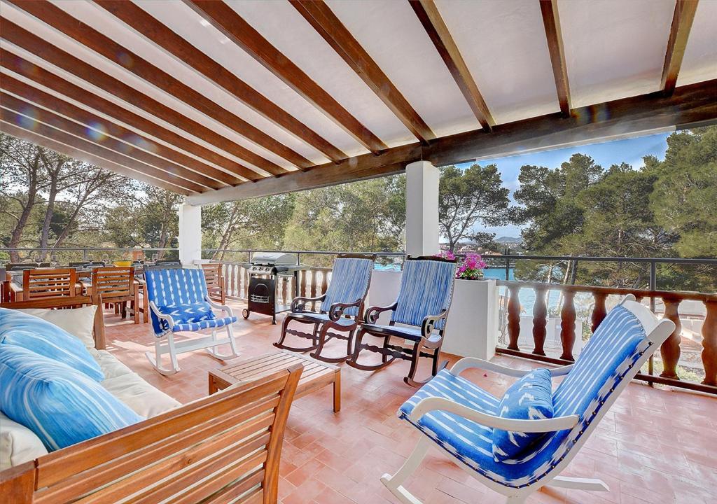 een patio met blauwe stoelen en een terras met uitzicht bij Ca Na Marieta House by Slow Villas in Portocolom