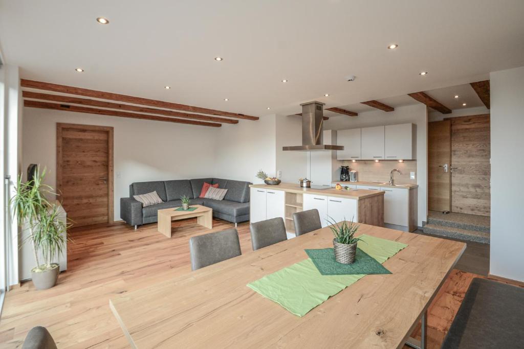 cocina y sala de estar con mesa de madera en Gästehaus Sonne, en Bichlbach