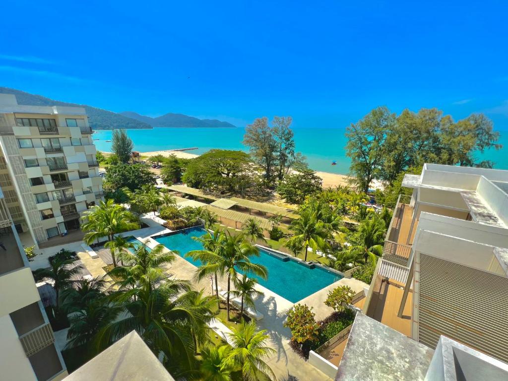 an aerial view of a resort with a swimming pool at By The Sea, Penang in Batu Ferringhi