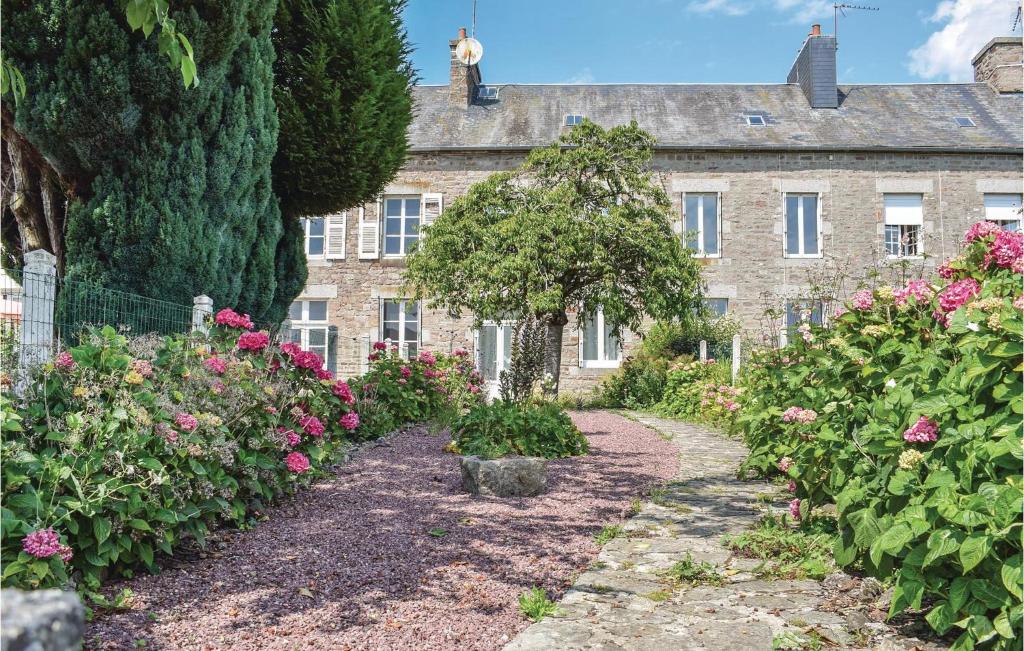 a garden in front of a house with flowers at 2 Bedroom Cozy Home In Le Beny Bocage in Le Bény-Bocage