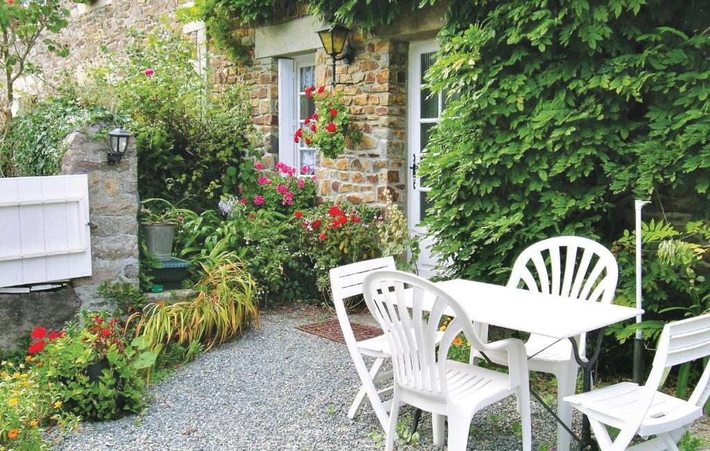 a table and chairs in front of a house with flowers at Stunning Home In Plouha With Kitchen in Plouha