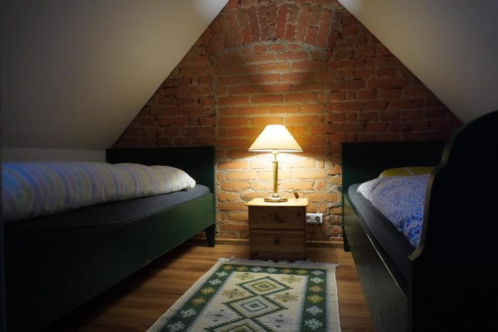 - une chambre mansardée avec 2 lits et une lampe dans l'établissement UDany Wypoczynek, à Wojanów