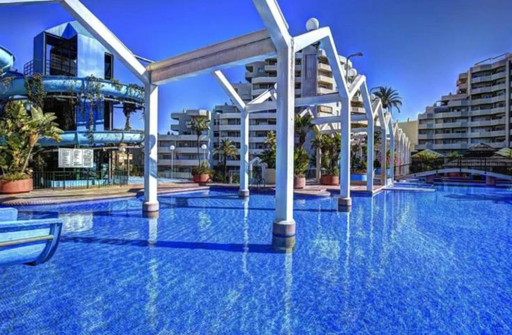 una grande piscina con acqua blu e edifici di Benal beach suite II, estudio con parque acuático y vistas al mar. a Benalmádena