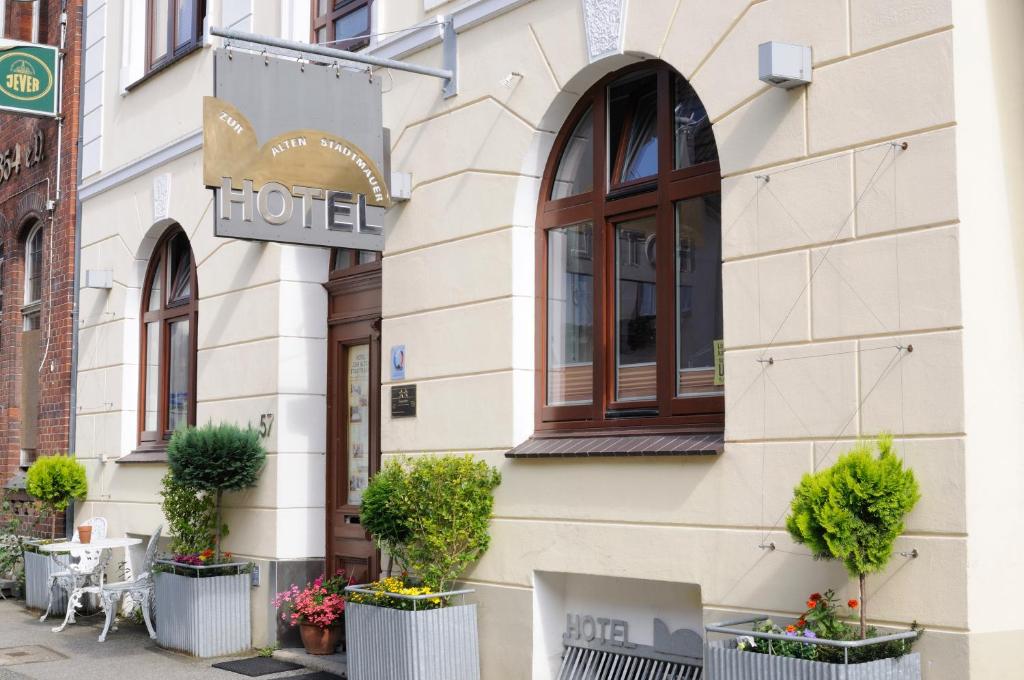 um hotel com vasos de plantas em frente a um edifício em Hotel zur alten Stadtmauer em Lübeck