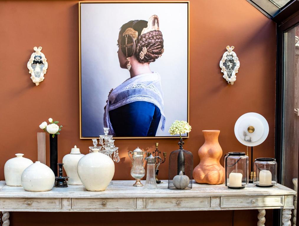une table avec des vases et une photo d'une femme dans l'établissement La Maison Ruffinoise, à Sainte-Ruffine