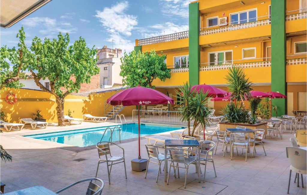 Stunning Apartment In Malgrat De Mar With 2 Bedrooms And Outdoor Swimming Pool في مالغرات دي مار: فناء الفندق به طاولات وكراسي ومسبح