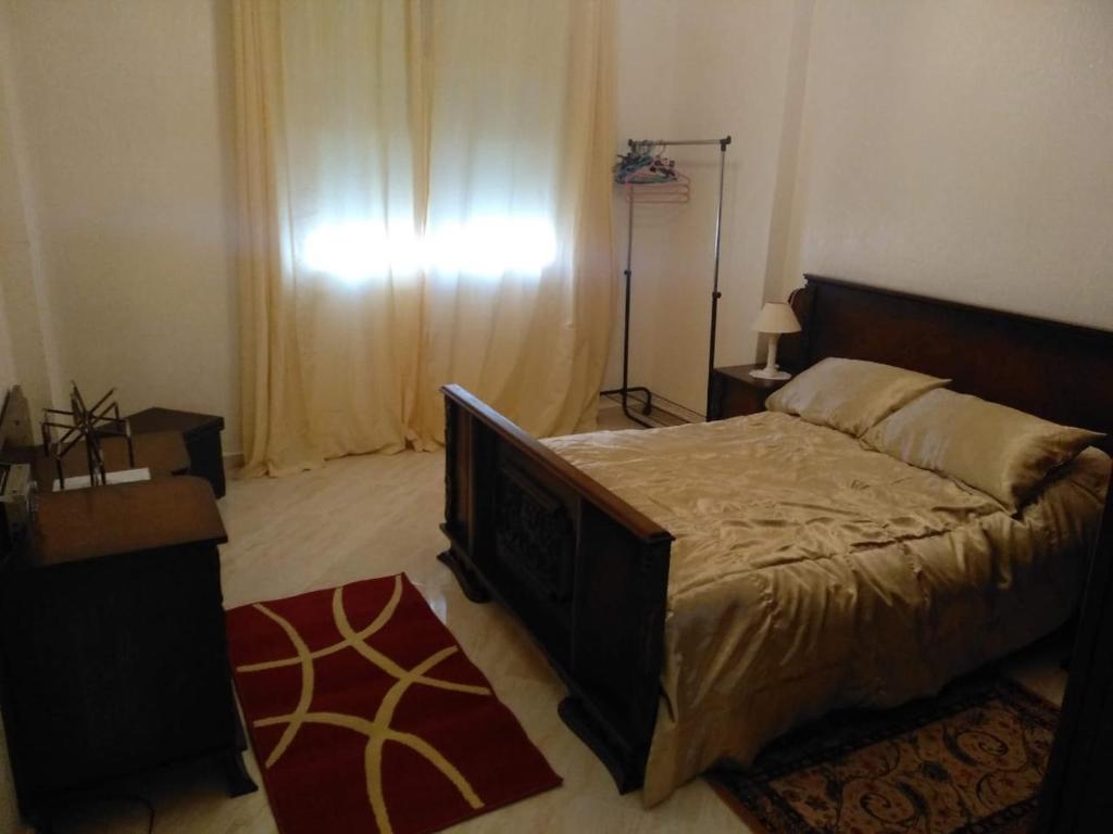 a bedroom with a large bed and a window at Appartement Bio Meknes Hamria in Meknès