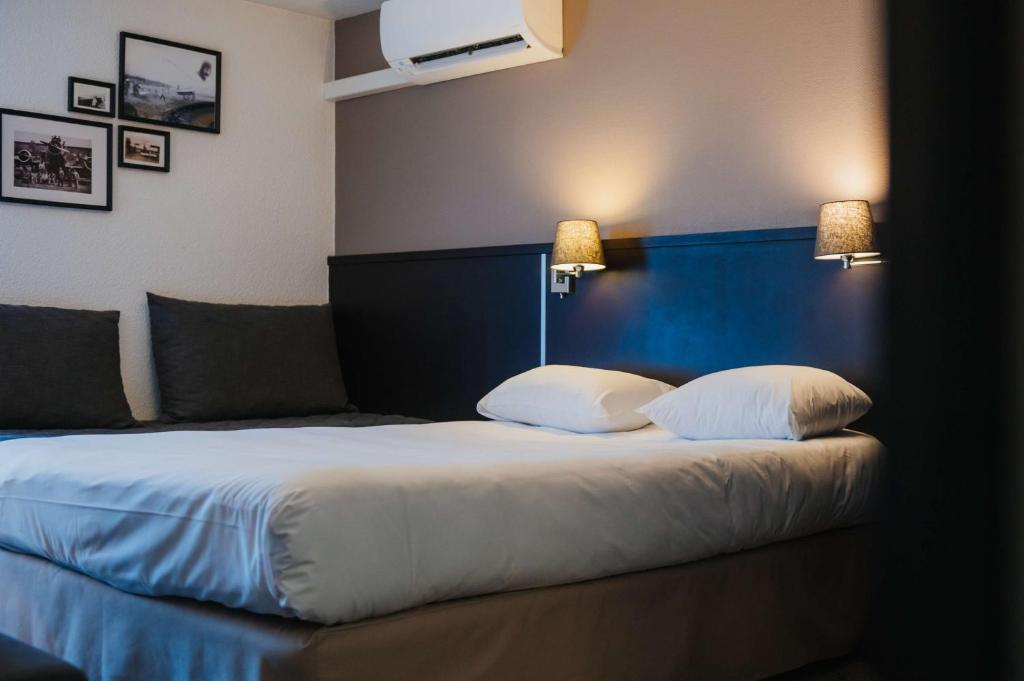 ein Schlafzimmer mit einem großen Bett und zwei Kissen in der Unterkunft Sure Hotel by Best Western Châteauroux in Le Poinçonnet