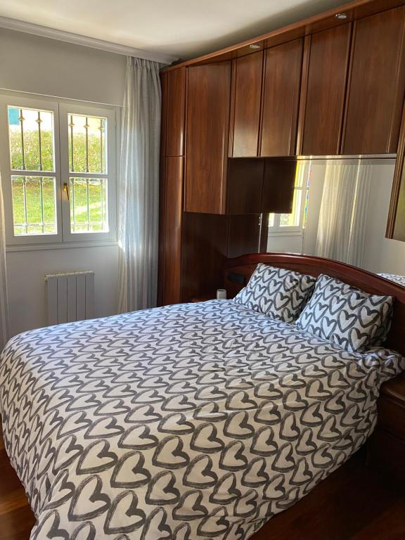 - une chambre avec un grand lit et des placards en bois dans l'établissement La Casa de Fito cerca del centro de Comillas, à Comillas