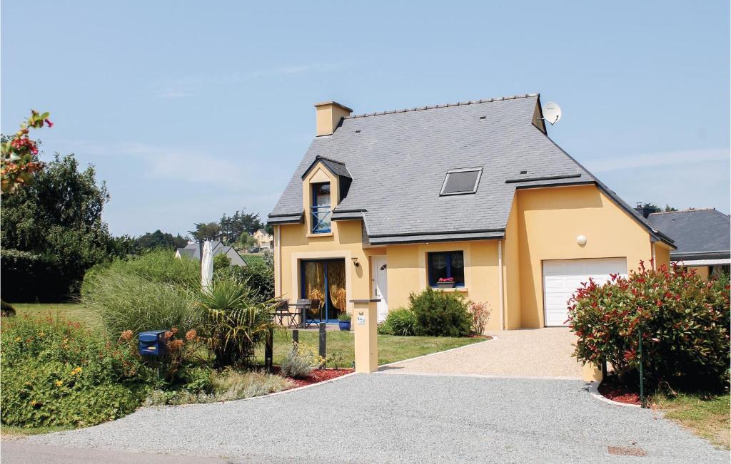 a yellow house with a garage and a driveway at Amazing Home In Lamballe-armor With 3 Bedrooms And Wifi in Planguenoual