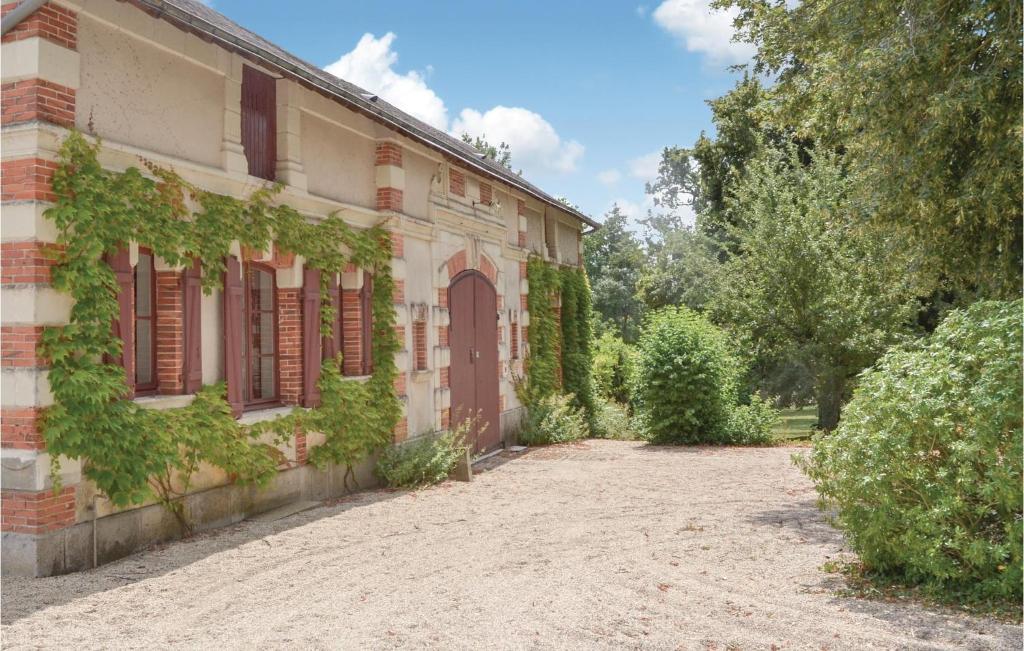 Ein altes Haus mit Efeu, der nebenbei wächst in der Unterkunft Stunning Home In Boure With Outdoor Swimming Pool in Saint-Brice